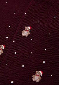 Weinroter Stoff mit strukturierter Oberfläche, der kleine cartoonartige Bären mit Weihnachtsmannmützen und weiße Schneeflockenmuster zeigt.