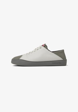 Lædersneaker med hvid overdel, grå tåhætte og en grå gummisål. Har et minimalistisk design med diskrete syninger og branding.