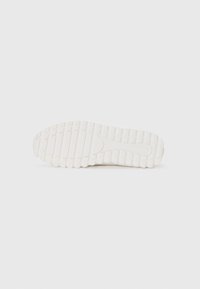 Weiße Sneaker-Sohle mit strukturiertem Surface und tiefen Rillen für gute Traktion. Das Design ist flach und ohne besondere Merkmale mit einer glatten Kante.