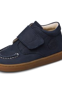Chaussure en suede bleu marine avec une bande Velcro, des coutures blanches et un bout arrondi. Dispose d'un logo circulaire sur le côté et d'une semelle en caoutchouc.