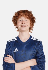 Maglia sportiva blu con un motivo a triangoli, caratterizzata da strisce bianche sulle spalle e un logo Adidas sul petto. Maniche lunghe.