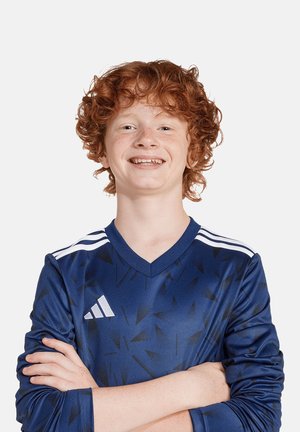 Maillot de sport bleu avec un motif triangulaire, présentant des rayures blanches sur les épaules et un logo Adidas sur la poitrine. Manches longues.