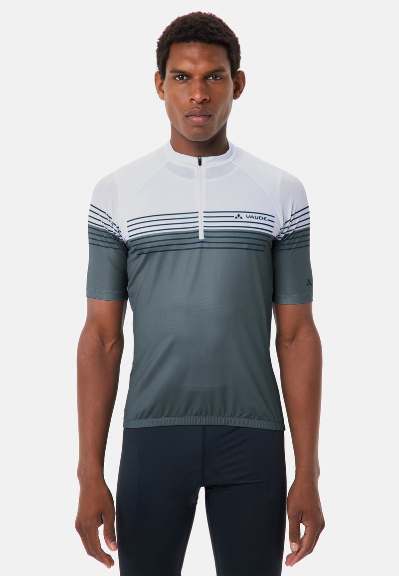 Homme portant un maillot de cyclisme à manches courtes gris et blanc à rayures horizontales avec une fermeture éclair partielle à l'avant, debout devant un fond blanc.