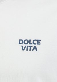 Camiseta blanca de canalé con el texto "DOLCE VITA" en azul marino, centrado en el pecho, con un diseño de cuello redondo.