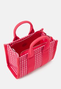 Sac à main en tissu à carreaux rouges avec des poignées en tissu doubles et une fermeture à glissière ; dispose d'un intérieur spacieux et de rayures d'accent de couleur unie.