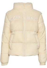 Krämfärgad pufferjacka med en plyschshearlingövre och en slät nedre del. Har en hög krage och broderad "KARL KANI" framtill.