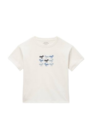 T-shirt blanc manches courtes pour enfants avec neuf petits nœuds brodés en noir, bleu foncé et bleu clair centrés sur le devant.