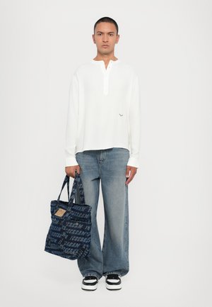 Hvit langermet skjorte, løstsittende blå jeans, og marineblåmønstret totebag med svart og hvite joggesko. Enkelt design og uformell stil.
