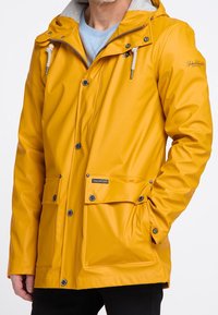 Yellow waterproof jacket features a smooth, shiny texture with snap buttons, front pockets, and a contrasting grey lined hood.