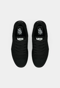 Čierne tenisky Vans s textúrovaným zvrškom, perforovanými detailmi, plochými šnúrkami a logom na jazyku. Klasický nízky dizajn.