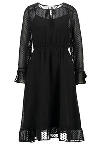 Černé šaty z průsvitné látky s puntíky, s dlouhými rukávy, elastickým pasem a volánovými manžetami a lemem. Výstřih s klíčovou dírkou a zavazováním.