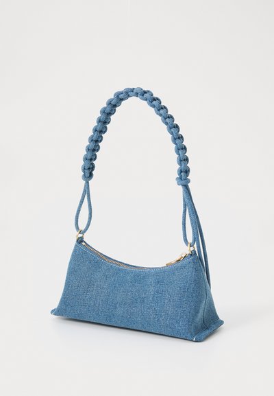 Denim håndtaske med en struktureret triangulær form, dyb blå farve, flet-hank og guld lynlås-lukning. Tekstureret stof finish.
