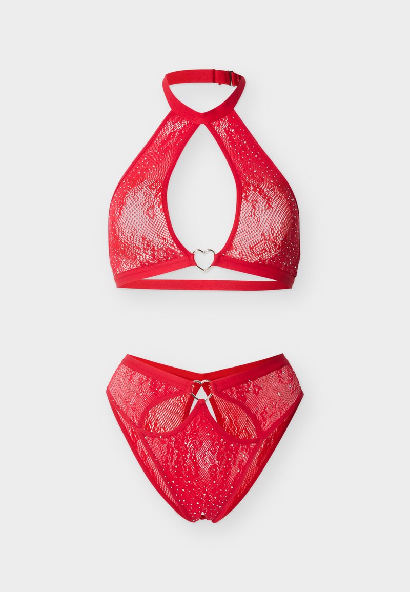 Σετ κόκκινο δαντελωτό σουτιέν με λουριά και αντίστοιχο εσώρουχο με μεταλλικούς κρίκους σε σχήμα καρδιάς και διακριτικές λαμπερές λεπτομέρειες σε λευκό φόντο.