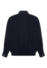 Giacca pullover blu navy con una vestibilità morbida, dotata di colletto, orlo arricciato e polsini con bottoni. Tessuto liscio con texture minima.