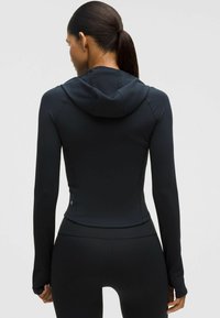 Fekete, testre simuló sportdzseki kapucnival, hosszú ujjal, sima felülettel és szabott szilüettel, lapos varrásokkal és logó részlettel.