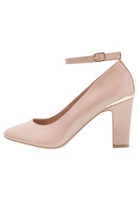 Rosa lackläder högklackad sko med rund tå, ankelsnodd och en guldaccent på klacken. Enfärgad, slät textur.