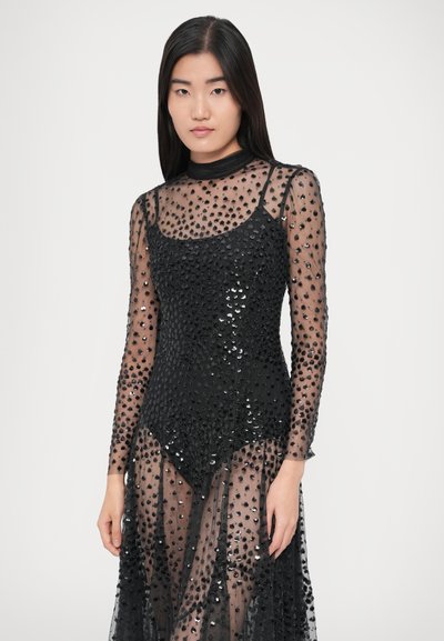 Black sequined dress featuring a sheer overlay, long sleeves, and a fitted bodice. The fabric has a textured and glossy finish.