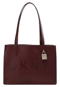 Torebka DKNY w burgundowej skórze, z wytłoczonym logo, gładką teksturą, strukturalnym designem i srebrnym detalem w postaci kłódki.