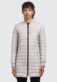 Jachetă puffer de culoare gri deschis, cu cusături orizontale, fermoar frontal, buzunare laterale și manșete striate. Prezintă sigla pe piept.