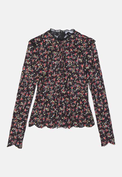 Musta pitkähihaine paita, jossa on punaisia, keltaisia ja vihreitä kukkakuvioita. Kaula-aukossa on pitsireunus ja helma on röyhelöinen.