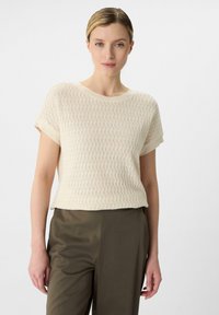 Lichtromige gebreide top met korte mouwen, met een gestructureerd patroon, ronde halslijn, contrasterende ribgebreide manchetten en een relaxed fit.