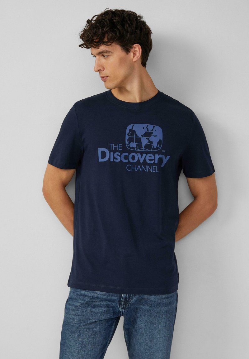 Granatowa bawełniana koszulka z krótkim rękawem, ozdobiona niebieską grafiką przedstawiającą glob oraz napisem "The Discovery Channel". Okrągły dekolt.