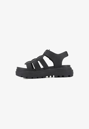 Black sandal featuring multiple wide straps with a textured finish, a thick rubber sole with traction patterns, and an adjustable heel strap.