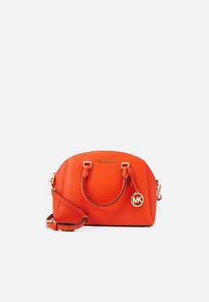 Oranje leren handtas van Michael Kors met dubbele handvatten, afneembare schouderriem en MK-logo bedel op een effen achtergrond.