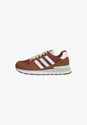 Braun-weißer Adidas-Sneaker mit weißen Schnürsenkeln, drei weißen Streifen an der Seite und einer Gummisohle mit strukturiertem Profil.