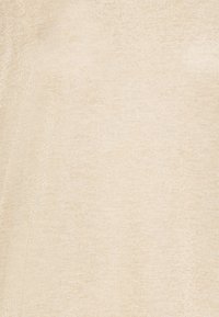 Béžová textilie s hladkou, lesklou strukturou a jemným leskem, zobrazující jednolitý vzor bez jakýchkoliv výrazných akcentů nebo kovových prvků.
