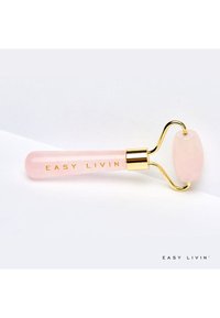 Rouleau facial en quartz rose avec un manche transparent rose, des accents dorés et du texte gravé "EASY LIVIN" sur le manche. Tête de rouleau ovale.