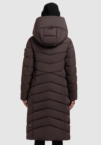 Brown long puffer coat with chevron quilting, large hood, and side pockets. Matte texture and durable fabric. Features brand logo near the hem.