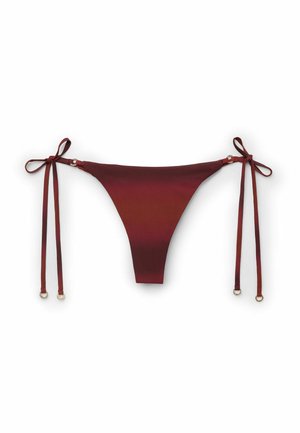 Burgundské spodní díly bikin s tenkými bočními zavazovátky zakončenými malými kovovými kroužky na bílém pozadí.