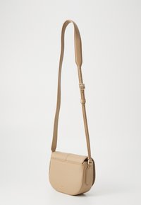 Borsa a spalla in pelle marrone chiaro con forma curva, superficie texturizzata e tracolla regolabile. Presenta una patta pieghevole e dettagli in metallo dorato.