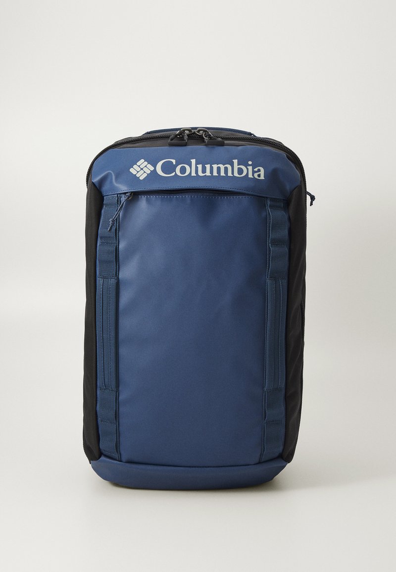 Columbia-reppu, jossa on tummansininen runko mustilla yksityiskohdilla, teksturoitu kangas, etutasku vetoketjulla ja logo ylhäällä.