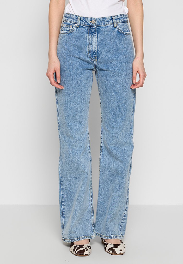 Jasnoniebieskie dżinsy z szeroką nogawką i wysokim stanem, z przednimi kieszeniami, subtelnymi przetarciami i lekko wyblakłym wykończeniem.