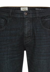 Donkerblauwe spijkerbroek met een reguliere pasvorm, voorzien van voorzakken, een knoopsluiting en subtiele textuurdetails in de stof.
