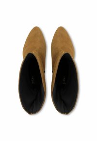 Barna velúr bokacsizmák hegyes orral és puha textúrával. Fekete belső bélés és minimalista dizájn, látható hardver vagy díszítés nélkül.