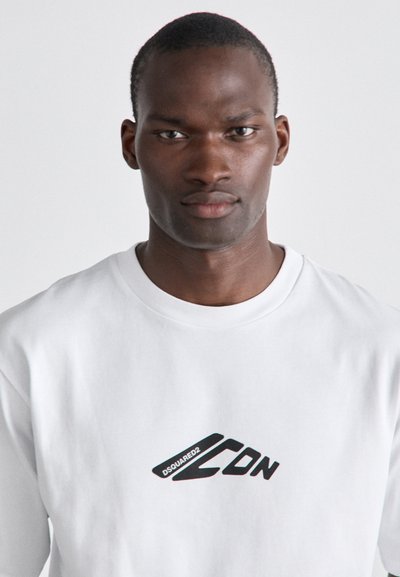 Chemise blanche à manches longues en coton, arborant un logo noir audacieux "DSQUARED2 CDN" sur le devant et un design classique à col rond.