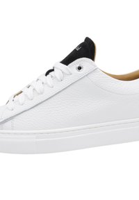 White leather sneaker with a textured surface, black suede accents on the tongue, and white flat laces. Rubber cupsole for grip.