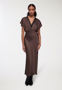 Abito maxi in satin marrone con scollatura a V, maniche a cappuccio e rifiniture in pizzo nero. Il design presenta un punto vita aderente e una silhouette fluida.