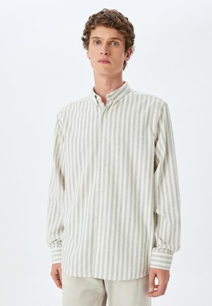 Camisa de manga larga abotonada en crema claro con sutiles rayas grises. Presenta un cuello clásico y mangas con puños, con acentos de rayas horizontales.