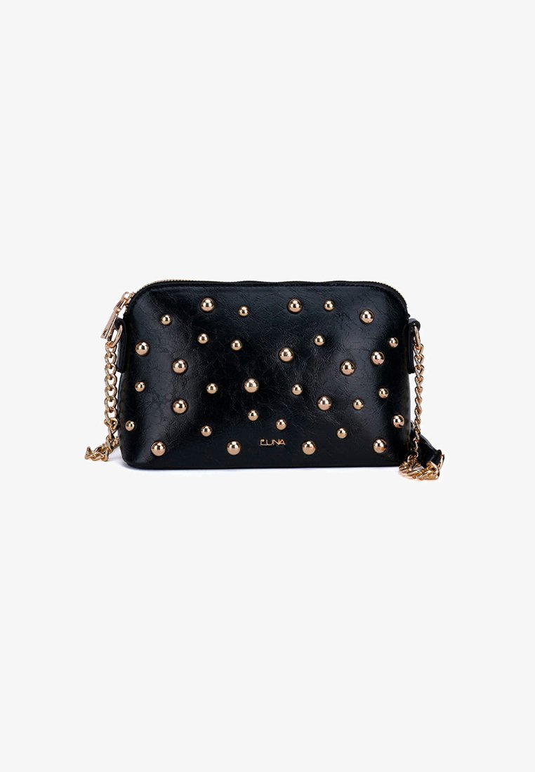 Bolso cruzado de cuero negro con tachuelas doradas, cierre de cremallera y correa de cadena. Textura suave con forma rectangular y detalle del logo.