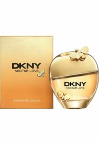 Guldtonad glasflaska i hjärtform med en bi-ackent, bredvid en guldask med "DKNY NECTAR LOVE" i fet svart text.