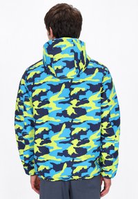 Hættejakke i blå, grøn og navy camouflage mønster. Har elastiske manchetter og en lynlåslomme på ryggen for bekvemmelighed.