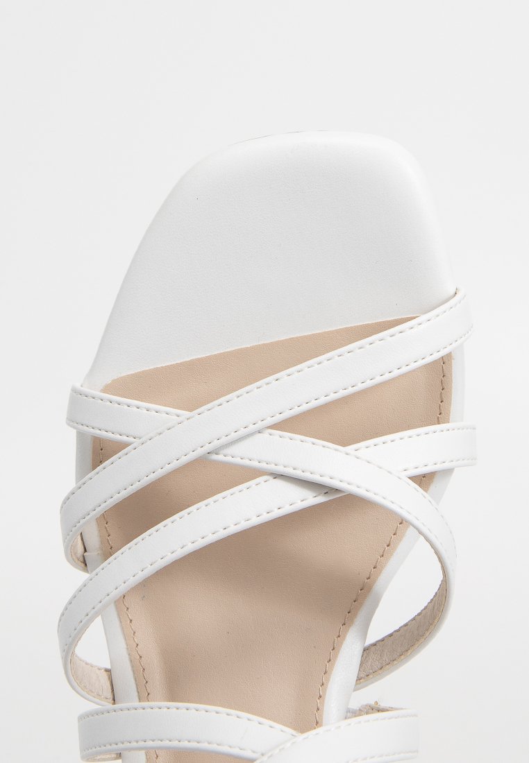 Sandale blanche avec un bout carré et plusieurs fines lanières en cuir entrecroisées sur une semelle intérieure beige.
