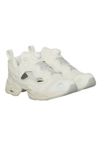 Scarpe da ginnastica bianche con superiore testurizzato, dettagli in rete e un sistema di allacciatura unico. Accenti in grigio chiaro e un design della suola arrotondata.