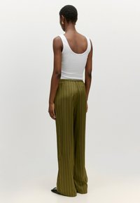 Witte geribbelde tanktop en olijfgroen gestreepte wide-leg broeken, met een relaxte pasvorm, elastische tailleband en minimalistisch ontwerp.