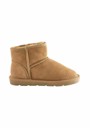 Stivale alla caviglia in suede marrone con una morbida fodera in pelliccia, suola piatta in gomma, dettagli sulle cuciture laterali e design con punta tonda.