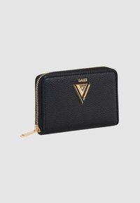 Portafoglio in pelle nera con superficie testurizzata, hardware dorato e logo triangolare. Presenta una chiusura a zip e una forma rettangolare compatta.